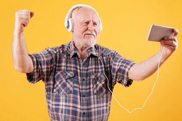 Happy senior dancing and watching video music