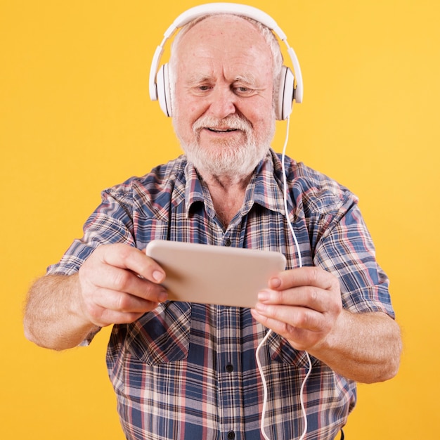 Foto gratuita uomo senior felice che guarda video musica