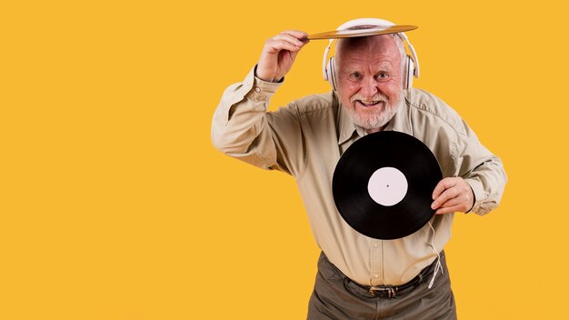 Happy senior playing with music records