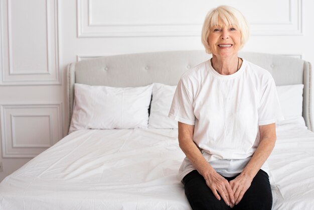 Happy senior sitting on bed