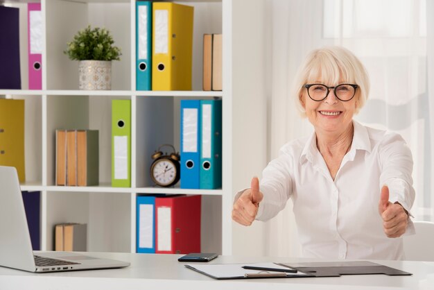 Happy senior sitting on her office