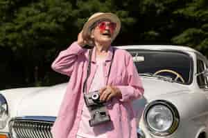 Бесплатное фото Счастливая старшая женщина, путешествующая в одиночестве на машине
