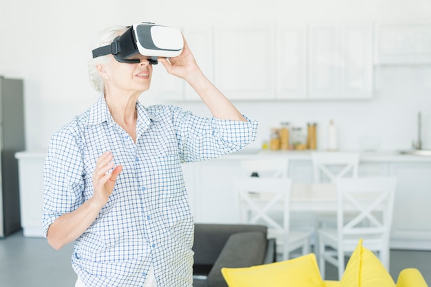 Happy senior woman using the virtual reality glasses