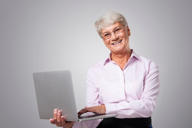 Happy senior woman with contemporary laptop