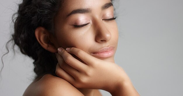 Happy serene young woman with beautiful olive skin and curly hair ideal skin and brown eyes in studio