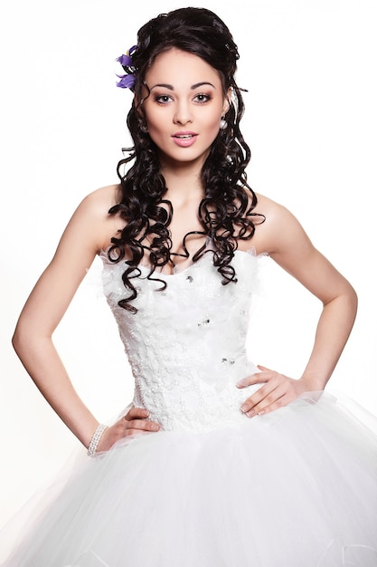 Happy sexy beautiful bride brunette girl in white wedding dress with hairstyle and bright makeup on white background