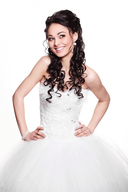 Happy sexy beautiful bride brunette girl in white wedding dress with hairstyle and bright makeup on white background