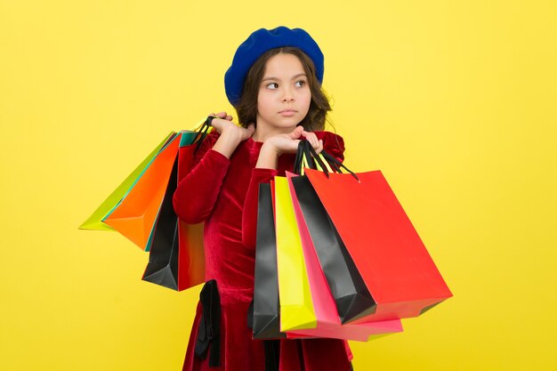 オンラインでハッピーショッピング。ショッピングモールでの大セール。誕生日とクリスマスプレゼント。国際こどもの日。ショッピングバッグを持つ小さな女の子の子供。買い物好き。