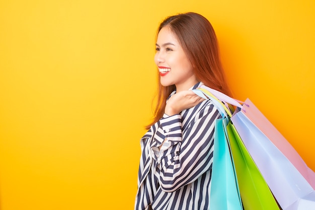 Premium Photo | Happy shopping woman on yellow background