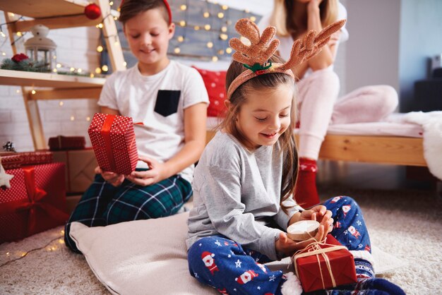 Happy siblings opening the christmas presents