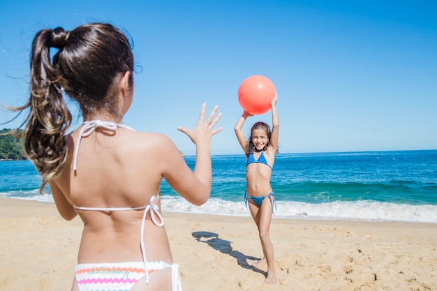 Happy sisters playing on the beach