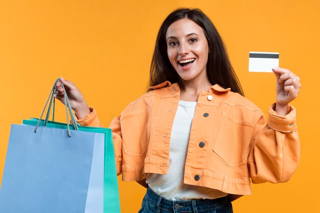 Happy smiley woman holding up credit card and shopping bags