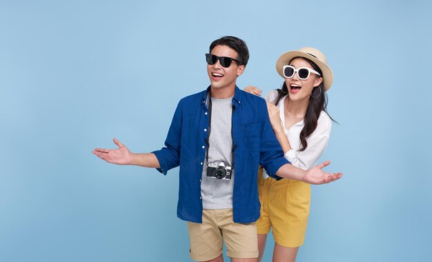 Счастливая улыбающаяся азиатская пара турист-путешественник стоит обнимаясь и глядя в пространство для копирования