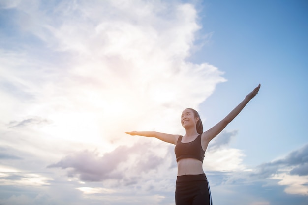 Free photo happy smiling athletic woman with arms outstretched