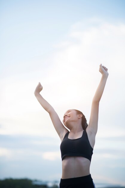 Happy smiling athletic woman with arms outstretched 