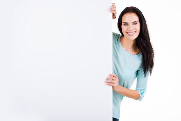 Happy smiling beautiful young woman showing blank signboard isolated on white