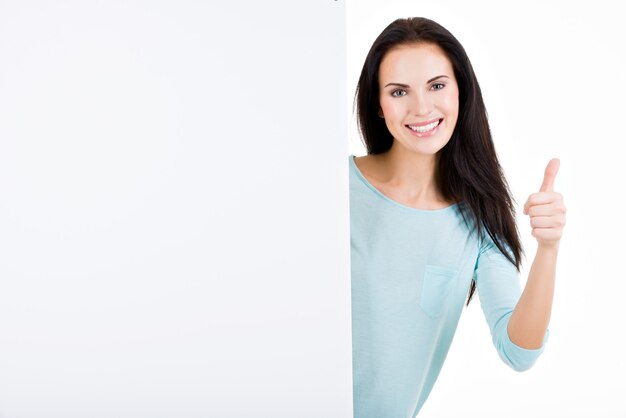 Happy smiling beautiful young woman showing blank signboard isolated on white