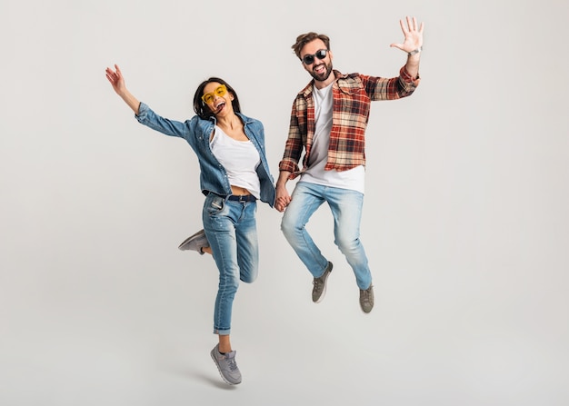 Happy smiling couple isolated active jumping on white studio