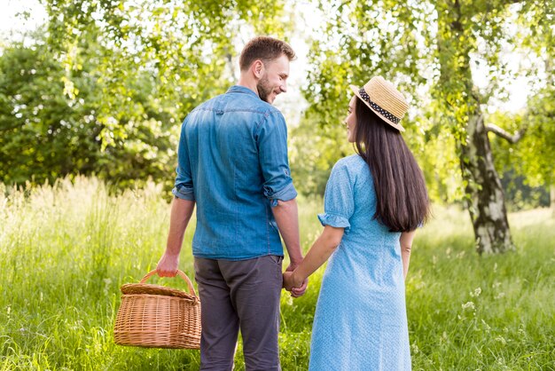 Happy smiling couple in love holding hands in park