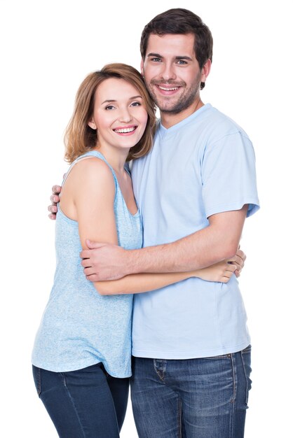 Happy smiling couple standing together looking at camera -  isolated