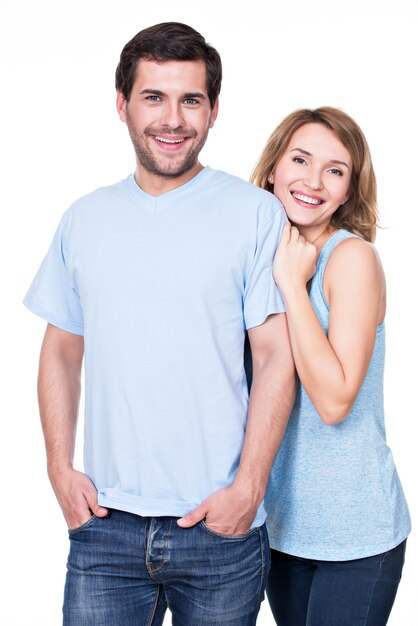 Happy smiling couple standing together looking at camera -  isolated