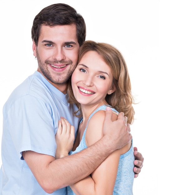 Happy smiling couple standing together looking at camera - isolated