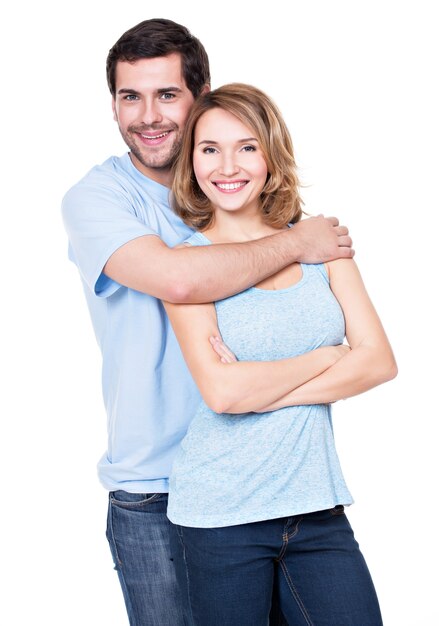 Happy smiling couple standing together looking at camera -  isolated