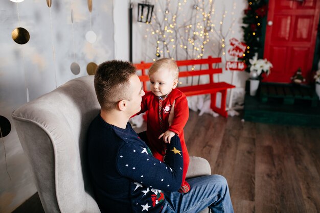 Free photo happy smiling family at studio on background of the christmas tree with gift