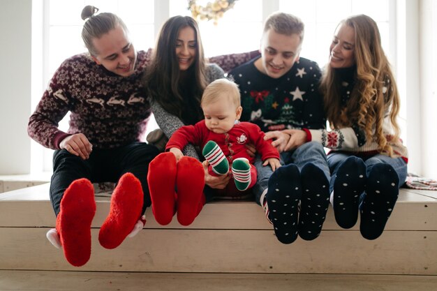 Happy smiling family at studio on background of the Christmas tree with gift