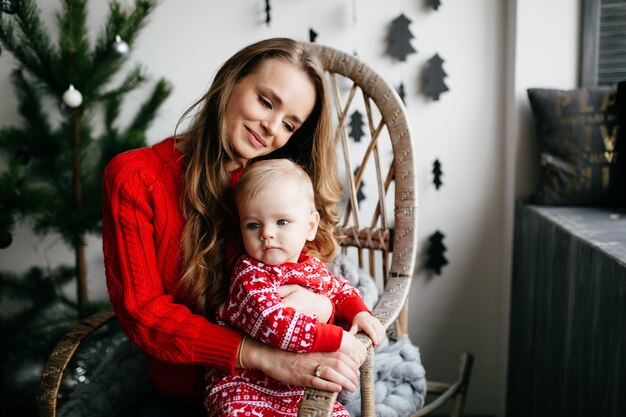 Happy smiling family at studio on background of the Christmas tree with gift