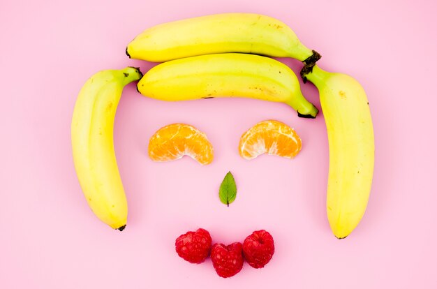 Happy smiling fruit face on light surface