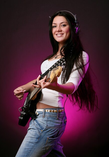 Happy smiling girl playing guitar