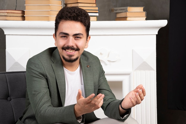 Free photo happy smiling handsome man sitting on chair.