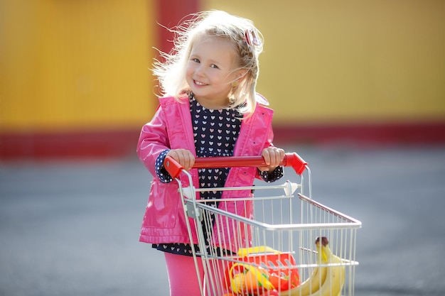 Happy smiling kid shopping Child with cart