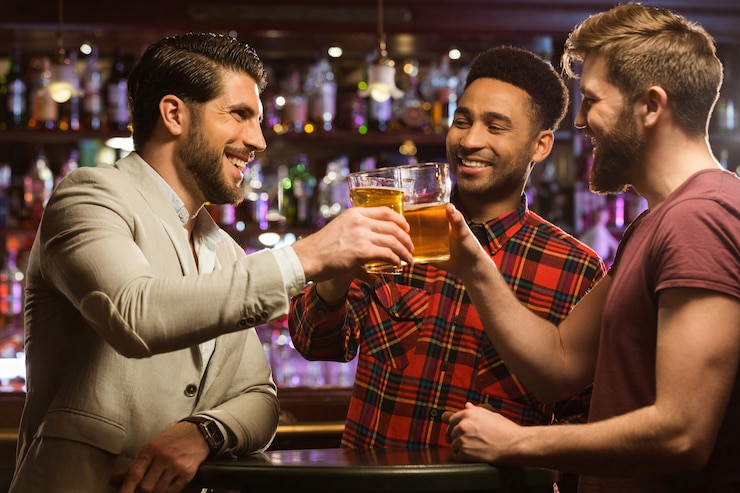 Free Photo happy smiling male friends clinking with beer mugs