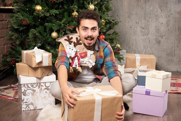 Happy and smiling man opening his gifts.