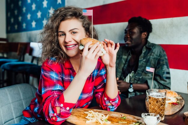 happy smiling woman having a resting in bar with man at cafe, talking, laughing eat fast food.