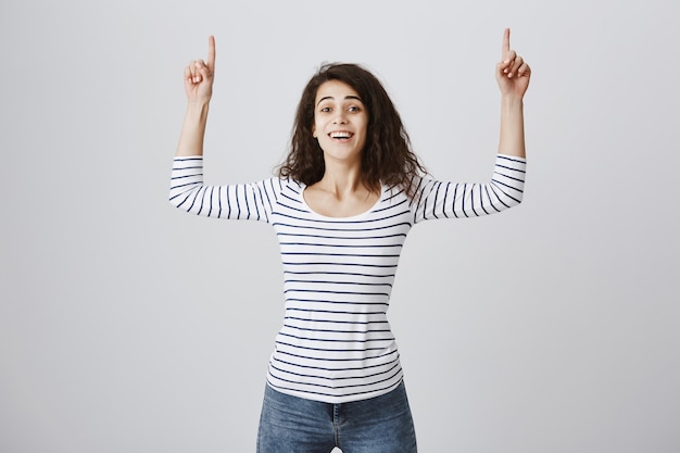 Free photo happy smiling woman pointing fingers up