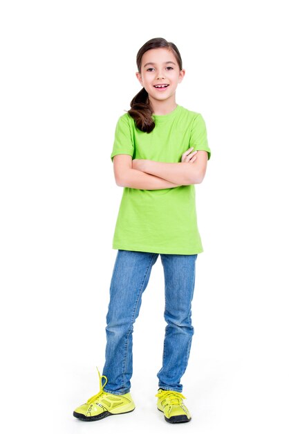 Happy smiling young girl with crossed hands looking at camera in full length standing on white background.