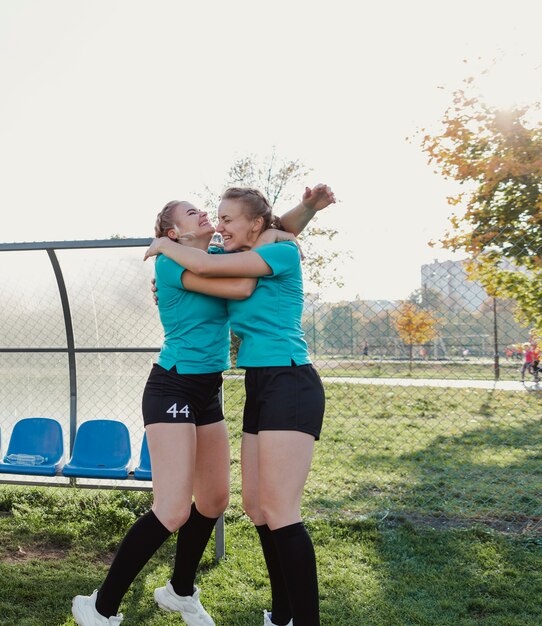 Foto gratuita ragazze sportive felici che si abbracciano