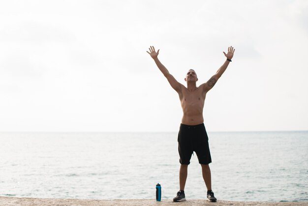 Happy sportsman enjoying training on shore