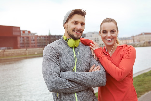 Happy sporty couple posing against the river