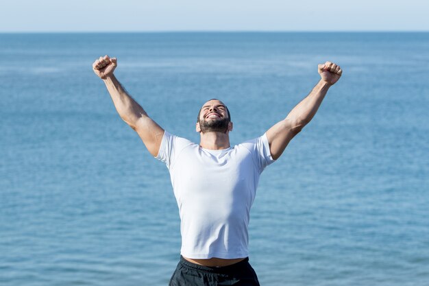 Happy Strong Man Celebrating Sport Success at Sea