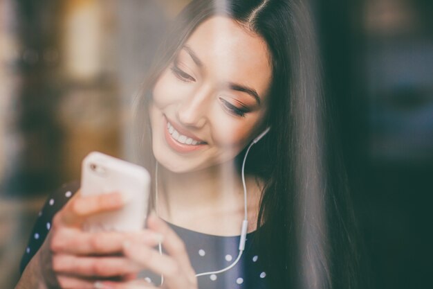 Happy student playing with her mobile