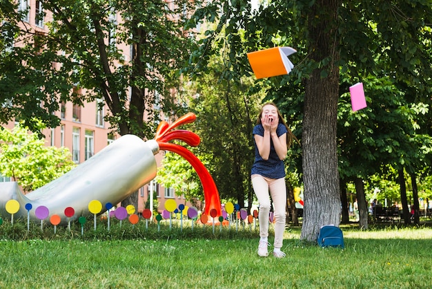 Foto gratuita studente felice lancia libri fuori