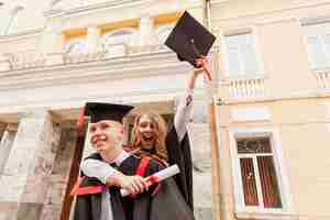 Foto gratuita felici studenti che celebrano la laurea