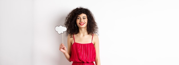 Happy stylish woman with curly hair beauty makeup holding comment cloud on stick and smiling standin