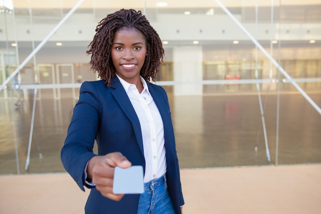 Foto gratuita agente di successo felice che dà la carta di nome