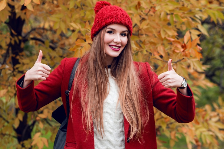 Free Photo happy successful blonde woman in red hat and jacket posing in autumn park.