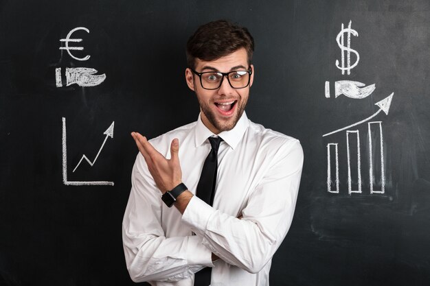 Happy successful businessman in white shirt presenting financial scheme